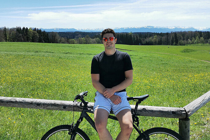 Young man with his mountainbike in front of Alpine Panorama