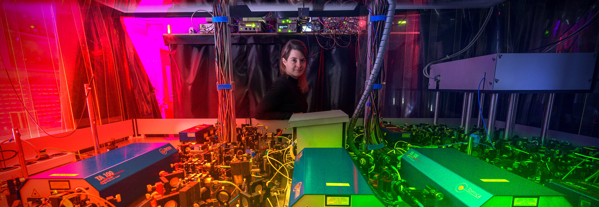 Monika Aidelsburger in front of an experimental setup for quantum experiments.