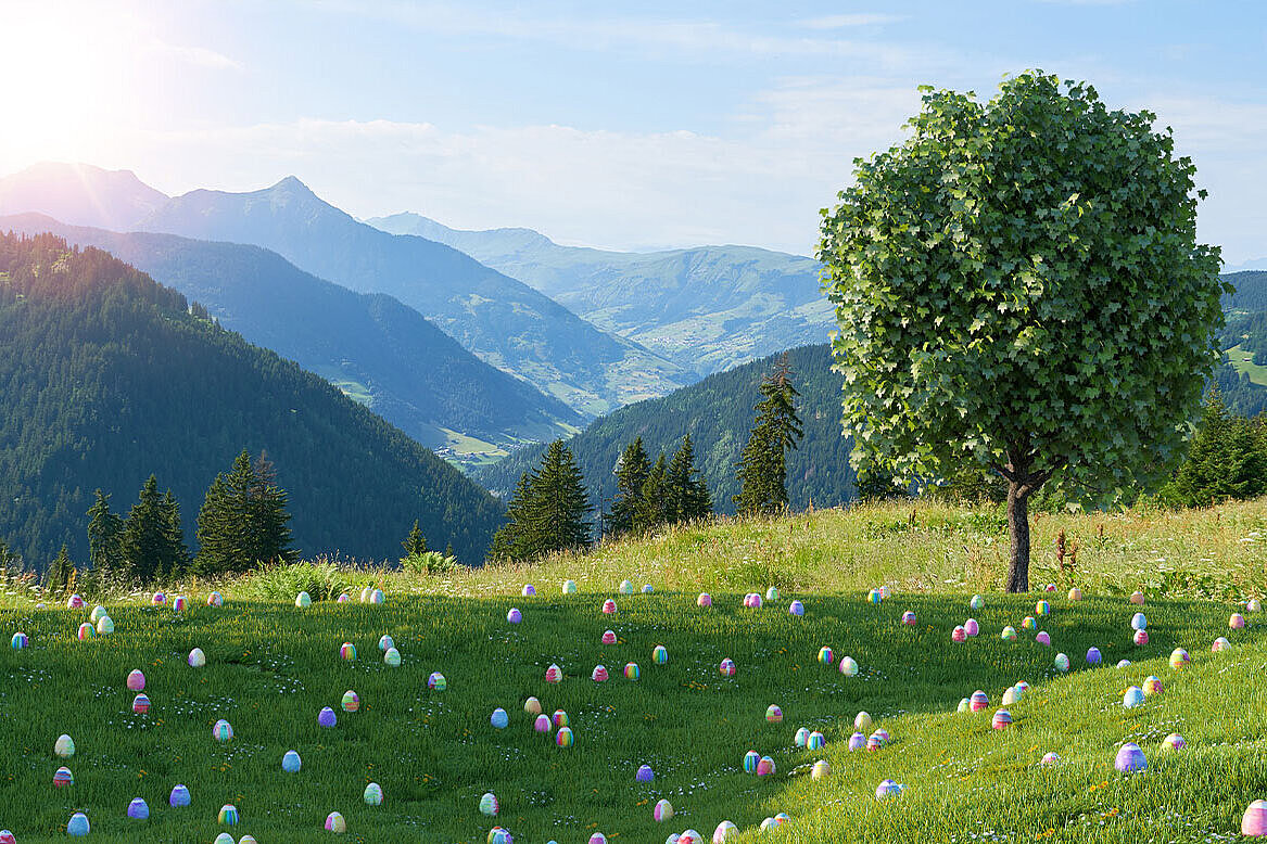 Plenty of coloured Eastereggs spread on green grass with mountains in the background