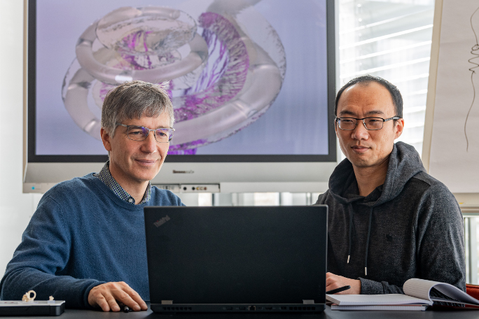 Prof. Hemmert and his postdoctoral researcher Siwei Bai working on a computer.