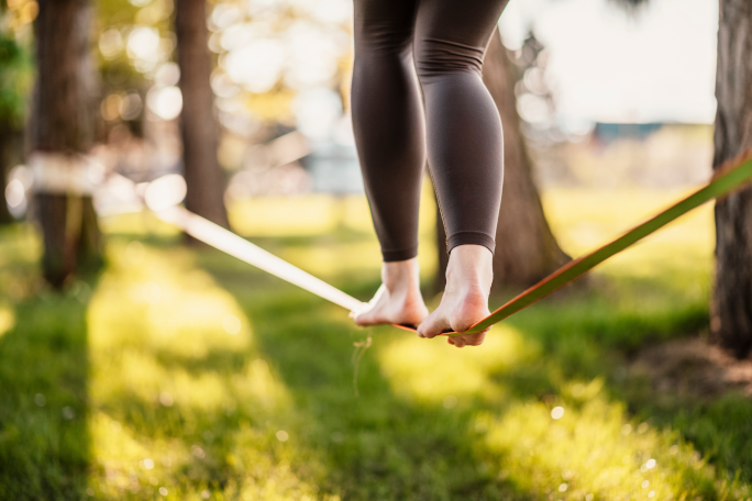 Person in a park slacklineing barefoot