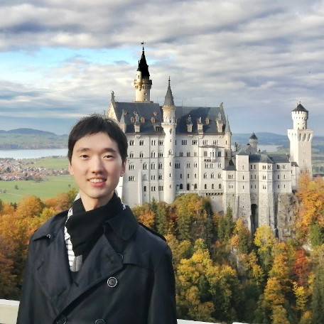 Jingkang Zhao and the Neuschwanstein Castle surrounded by colorful trees in the background