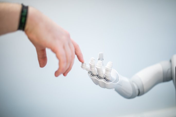 a human hand and a robot's hand touch each other