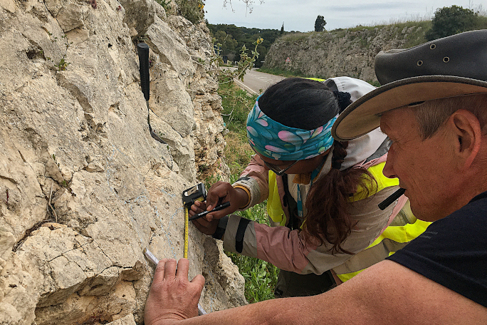 Paleogbiology research on a field trip: Professor Kießling is working with a colleague on a stone wall