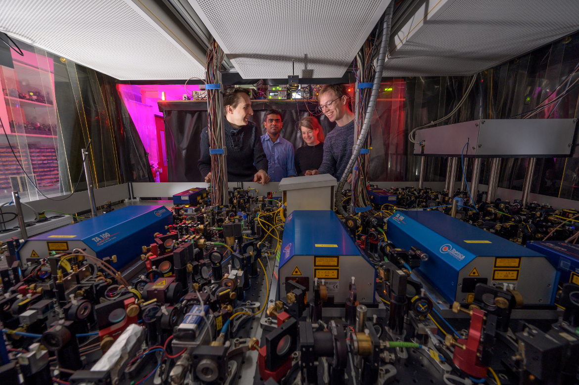 Four researchers behind the tools of the experimental setup