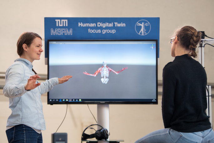 Two researcher in front of TV, which shows a human torso