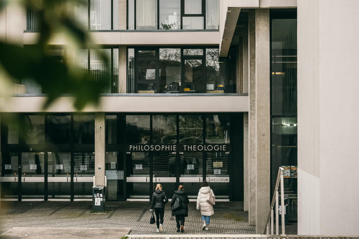 Three women entering the building. "Philosophie" and "Thologie" is written on a sign above the main entrance.