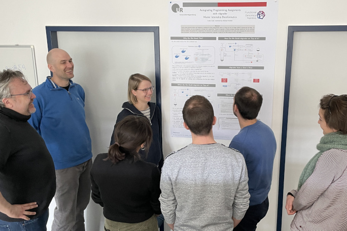 A group of seven people standing around a poster in the new Faculty of Informatics and Data Science.