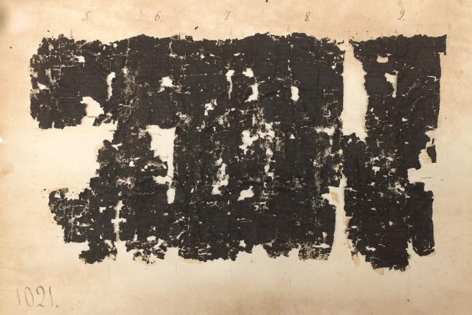 A very black and torn piece of papyrus.
