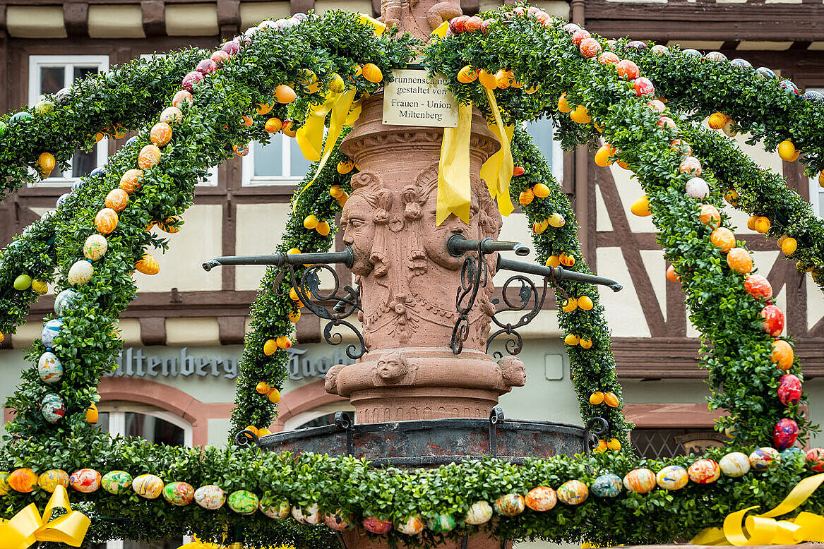 Artfully decorated fountain with easter eggs and palm fronds.