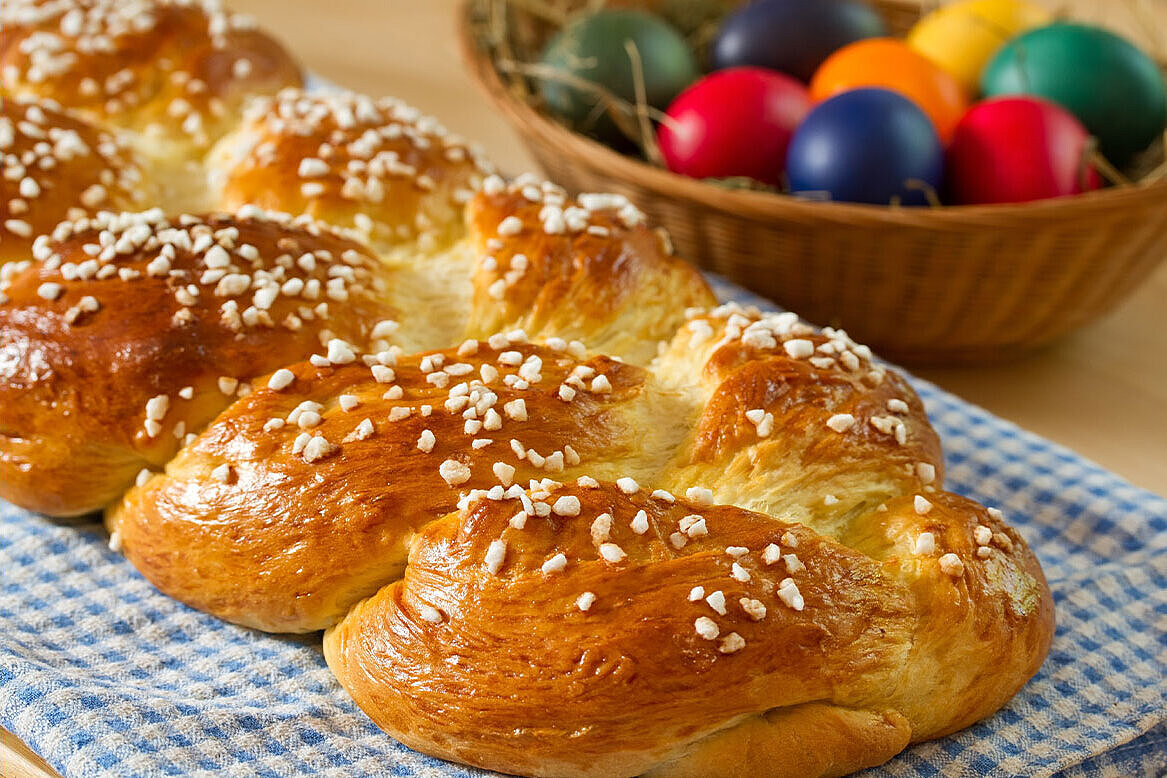 Braided yeast bread, with coloured eggs on a table