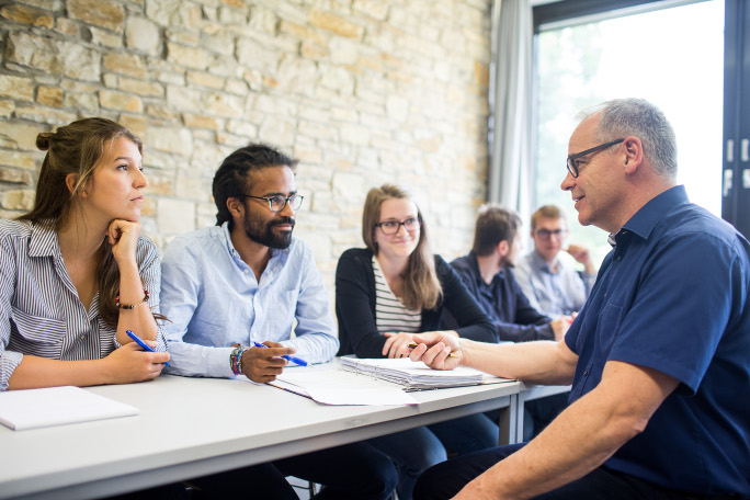 Professor training a group of international PhD candidates in a subject-specific course.