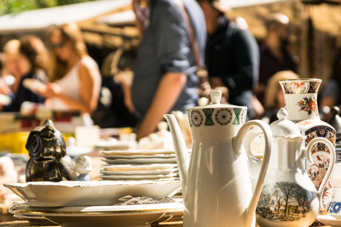 Random items and a tea set on a table on a flea market