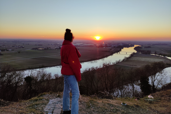 Sara watching the sunset from the top of a hill