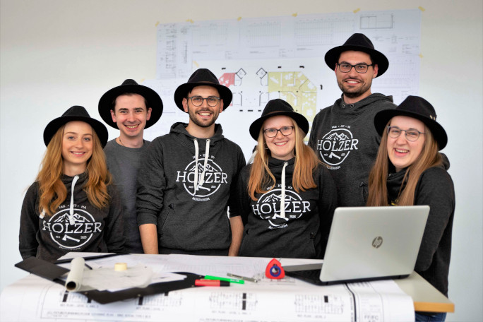 Group of students with the traditional Holzer hat smiling for the camera