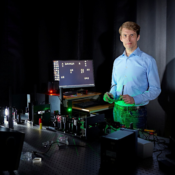 Professor Laquai standing in front of an experimental setup to research solar energy conversion