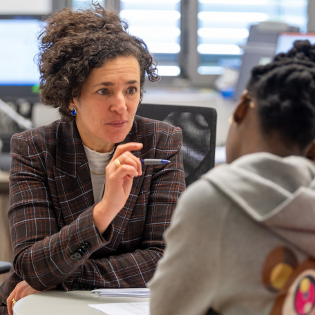 The professor and her international PhD student sit on a table and discuss worm infections.