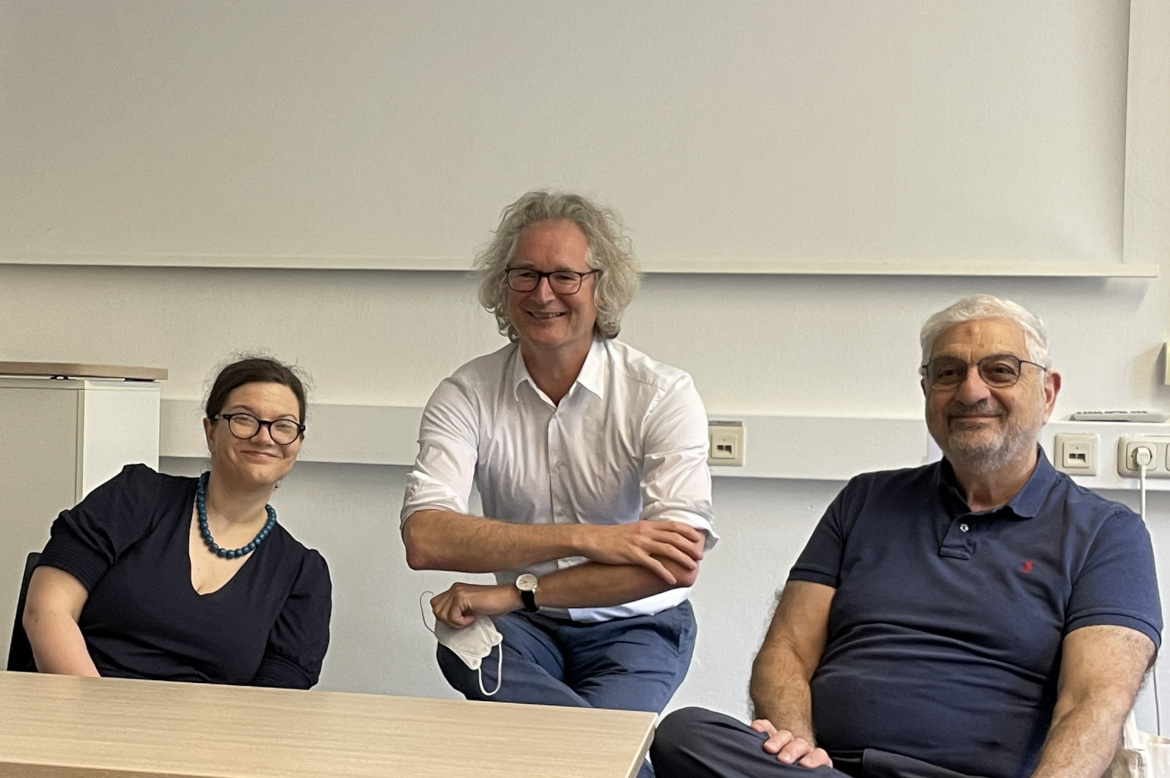Three researchers sitting in front of a white board after a seminar in area studies.