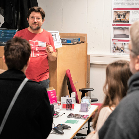 A researcher talking to a group of visitors at a lab of the new Faculty of Informatics and Data Science..