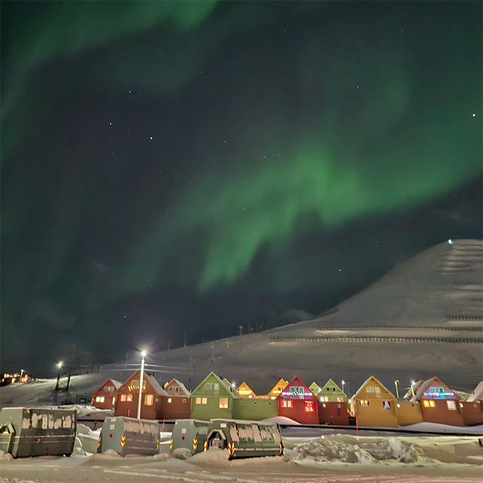 Green northern lights can be seen in the sky above Svalbard.