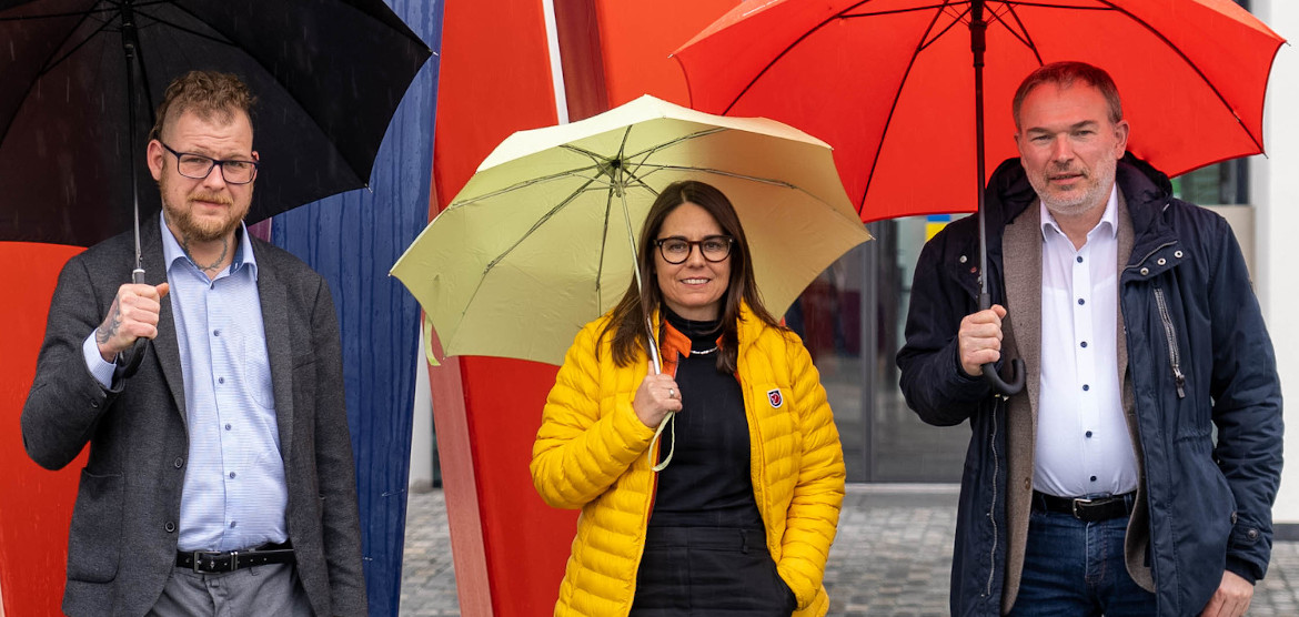 The three experts in sustainable water management with colourful umbrellas at the university campus.