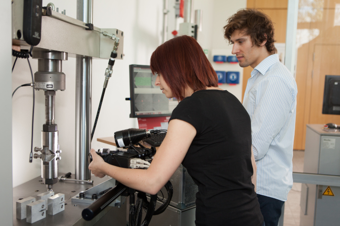 Two researchers working on a machine in the laboratory