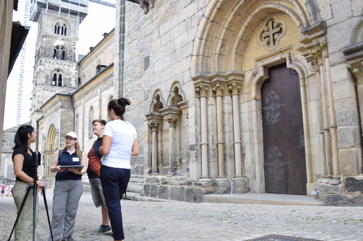 4 researchers in digital heritage conservation stand in front of a church