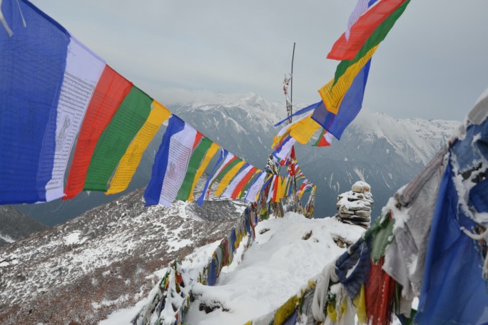 Prayer flags blowing in the wind with mountain panorama in the background