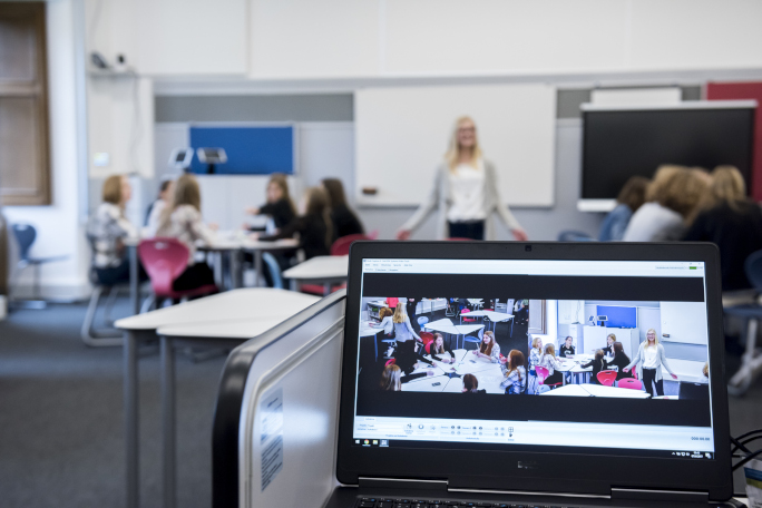 Teaching situation in a classroom with a laptop in the foreground